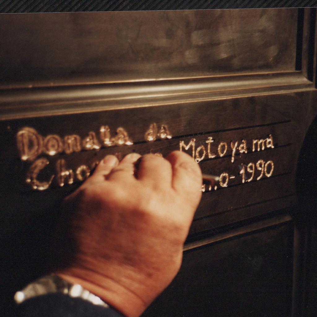 Choichiro Motoyama che fa la sua firma sul retro della replica delle Porte del Paradiso in Battistero 